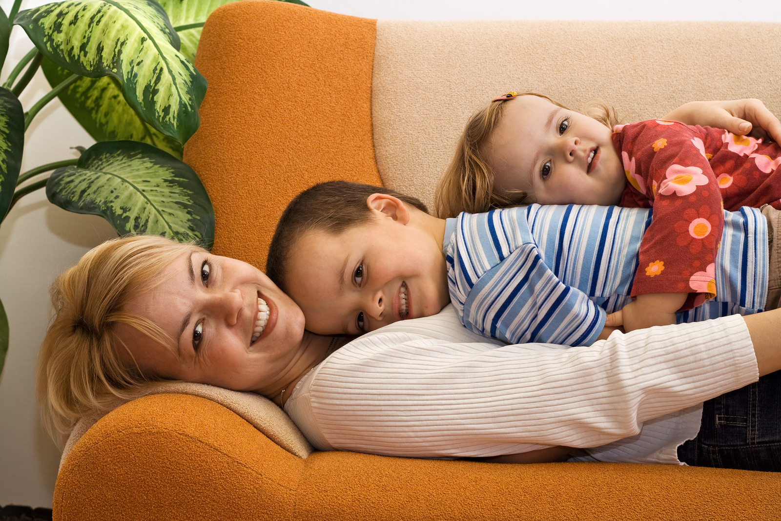 Woman and children together at home laying on the sofa