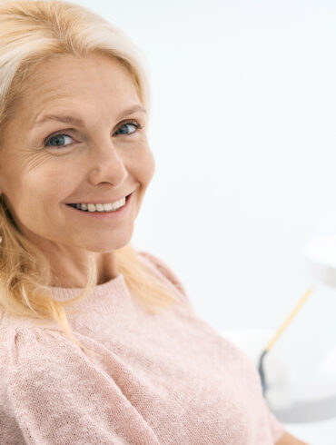 Pretty patient looking with smile in dental clinic