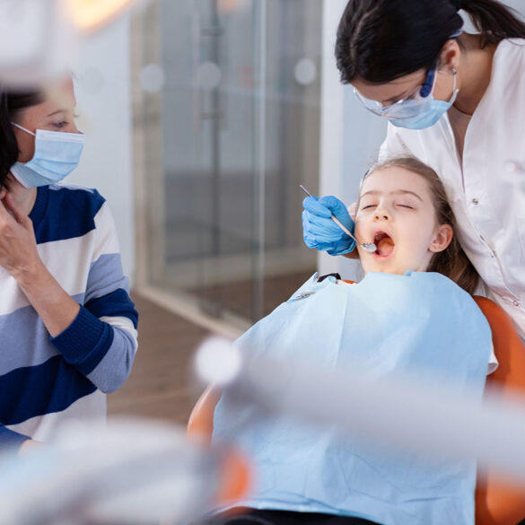 Family visit at dentist office for dental and oral hygine. Dentistry specialist during child cavity consultation in stomatology office using modern technology.