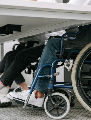 Photo by Ivan S: https://www.pexels.com/photo/person-in-blue-denim-jeans-sitting-on-blue-and-black-wheelchair-8127701/